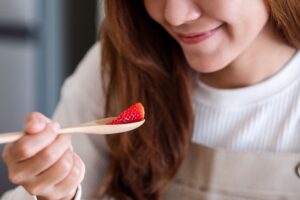 a young asian woman eating strawberry with spoon 2021 10 21 03 28 39 utc 1