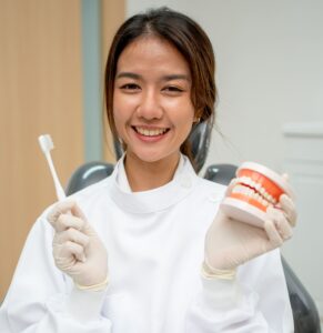 asian dentist woman hold teeth model and toothbrus 2021 12 09 11 20 22 utc 1 1 1