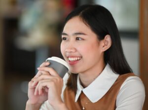 cheerful young woman smiling and holding a cup of 2021 12 20 22 01 13 utc